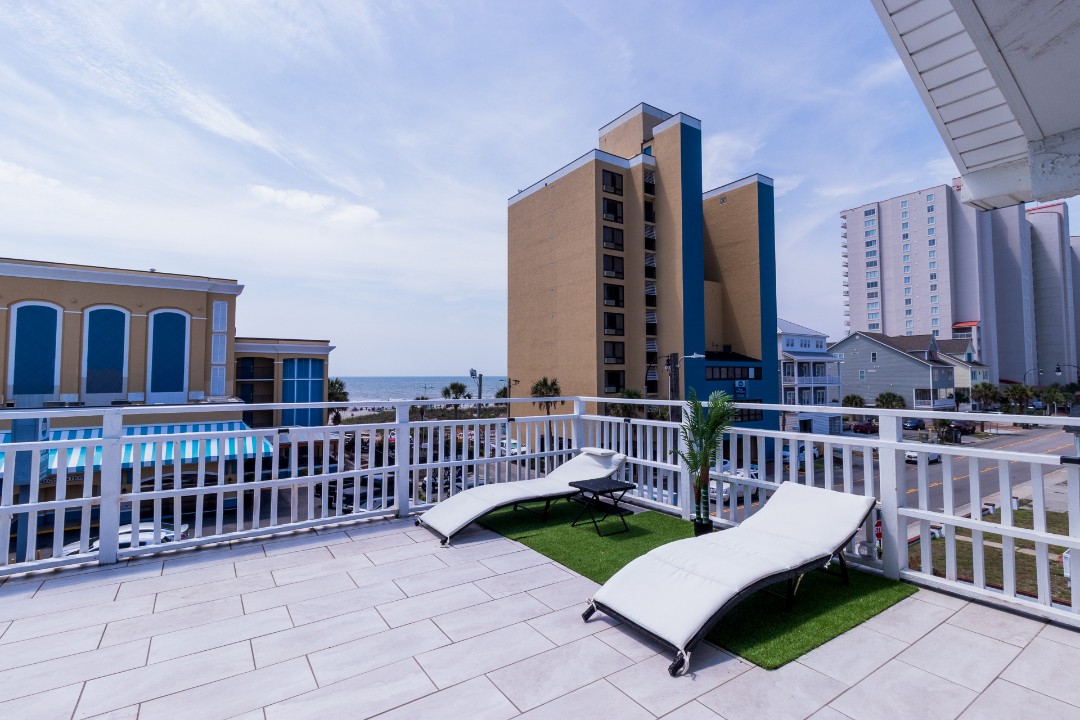 Private balcony lounge chairs with distant ocean views